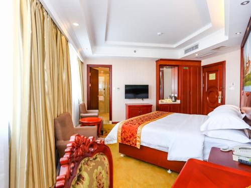 a hotel room with a bed and a television at Vienna International Hotel Shanghai Fengxian Nanqiao in Fengxian