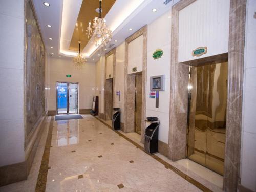 einen Flur in einem Gebäude mit einem Kronleuchter in der Unterkunft Vienna Hotel Nanchang Hongcheng in Nanchang