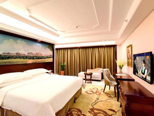 a hotel room with a large bed and a desk at Vienna Hotel Loudi Chunyuan Pedestrian Street in Loudi