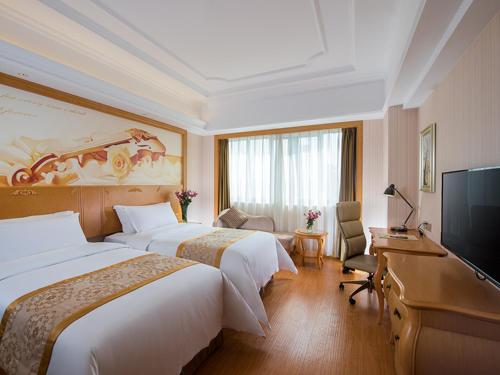 Habitación de hotel con 2 camas y TV de pantalla plana. en Vienna Hotel Foshan Nanhai Avenue Branch, en Foshan