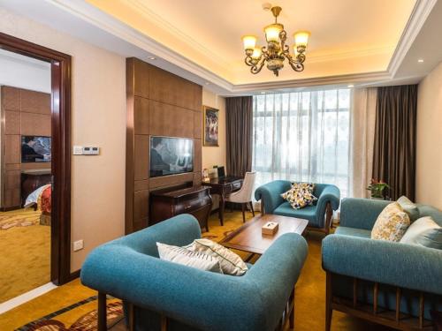 a living room with blue couches and a table at Vienna International Hotel(Hangzhou Xiasha University City) in Hangzhou