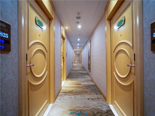 a corridor of a hallway with yellow doors and a tile floor at vienna hotel (HuaZhong Agricultural University in South Lake Store) in Wuhan