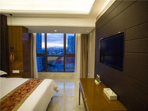 a hotel room with a bed and a large window at Vienna Hotel Sanya Sanya Bay in Sanya
