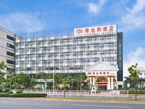 un grande edificio con un gazebo di fronte di Vienna Hotel Shenzhen Fuyong Subway Station a Bao'an