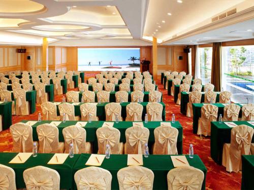 a room with a bunch of chairs and tables at Vienna International Hotel Shenzhen Dameisha in Shenzhen