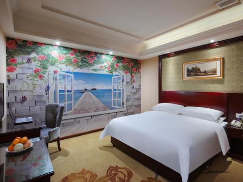 ein Schlafzimmer mit einem großen weißen Bett und einem Fenster in der Unterkunft Vienna Hotel Hengyang Zhengxiang in Hengyang
