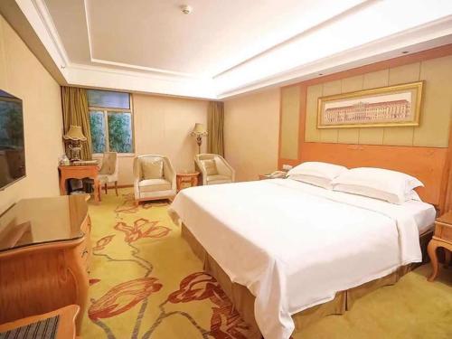 ShanweiにあるVienna Hotel Shanwei Chengqu Xingye Roadのベッドルーム1室(白い大型ベッド1台付)