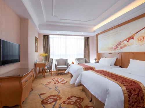 Habitación de hotel con 2 camas y TV de pantalla plana. en Vienna Hotel Dongguan Shi, en Dongguan