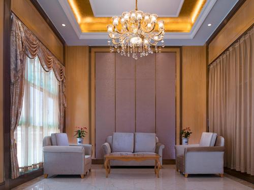 a waiting room with chairs and a chandelier at Venus International Hotel Shenzhen Gongming Tianhong in Xitian