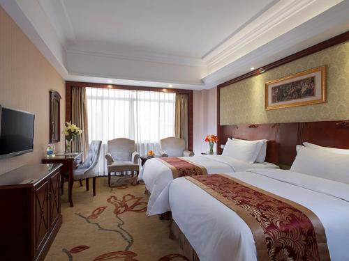 um quarto de hotel com duas camas e uma televisão em Vienna Hotel Shaoguan Wujiang Kuangshan Park em Shaoguan