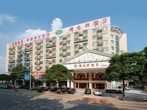 a large building with a sign on top of it at Vienna Hotel Foshan Lingnan Pearl Gymnasium Branch in Foshan