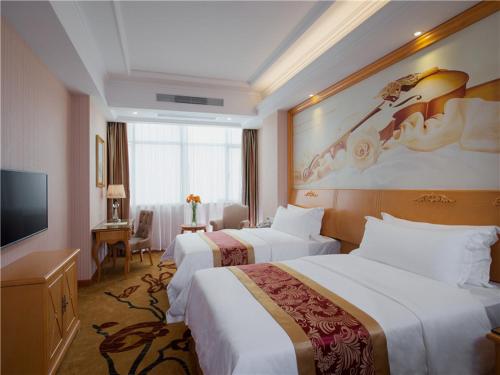 a hotel room with two beds and a television at Vienna Hotel Tianbao Road in Shenzhen