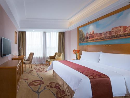 a hotel room with a large bed and a television at Vienna Hotel Foshan Lecong Furniture Mall in Shunde