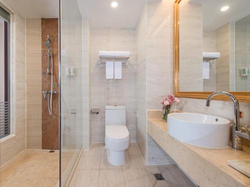 a bathroom with a toilet and a sink and a shower at Vienna Hotel Foshan Nanhai City Square in Foshan