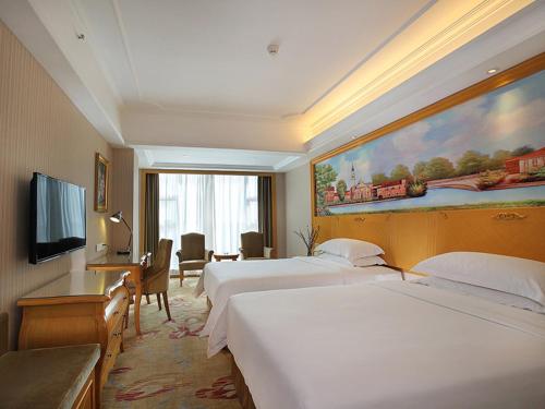 TianmenにあるVienna Hotel Hubei Tianmen Donghu Internationalのベッド2台とテレビが備わるホテルルームです。