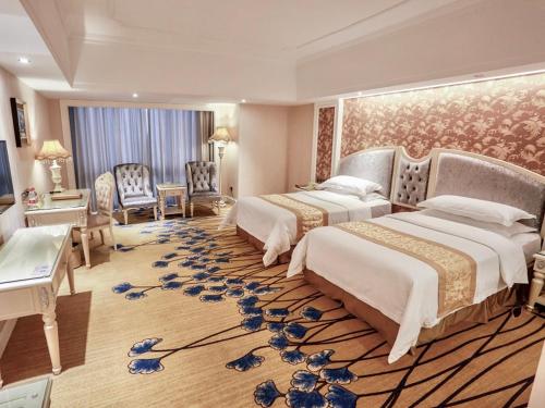 a large hotel room with two beds and a rug at Vienna International Hotel Jieyang People's Avenue in Jieyang
