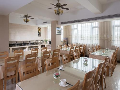 a large dining room with tables and chairs at Vienna International Hotel Jieyang Chaoshan Airport in Jieyang