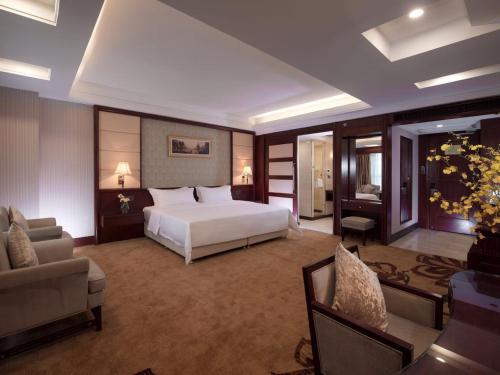 a hotel room with a bed and a couch and a couch at Vienna Hotel Foshan Nanzhuang Avenue in Foshan