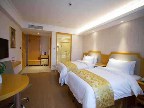 Rúm í herbergi á Vienna 3 Best Hotel Taizhou Xianju