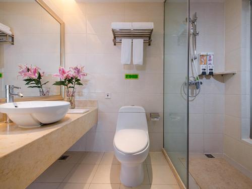 a bathroom with a toilet and a sink and a shower at Vienna International Hotel Shenyang Railway Station in Shenyang