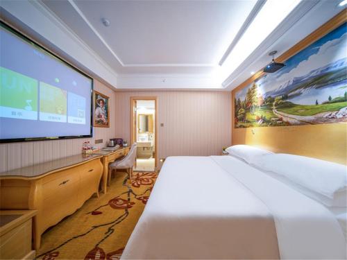 a hotel room with a bed and a large screen at vienna hotel (HuaZhong Agricultural University in South Lake Store) in Wuhan