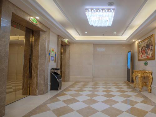 a lobby with a chandelier in a building with a checkered floor at Vienna Hotel Huizhou Chenjiang Avenue in Huizhou