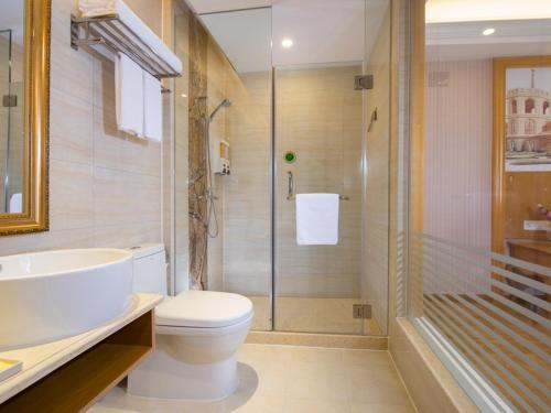y baño con aseo, ducha y lavamanos. en Vienna Classic Hotel Shenzhen Bantian Wuhe Avenue, en Shenzhen