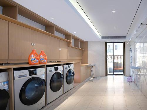 a laundry room with washing machines and orange vases at Vienna Hotel Shenzhen Exibition Center in Shenzhen