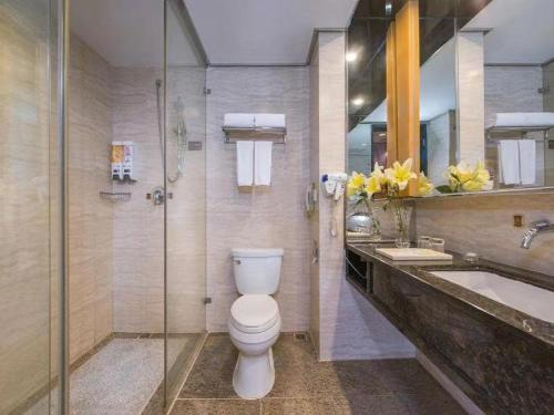 La salle de bains est pourvue de toilettes, d'un lavabo et d'une baignoire. dans l'établissement Vienna International Hotel - Foshan Haiyue Branch, à Nanhai