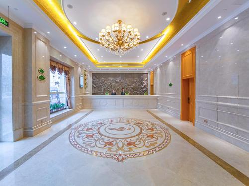 a large room with a chandelier and a large rug at Vienna Hotel Whhan xingye road stone bridge subway station store in Wuhan