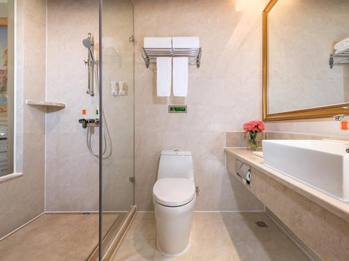 e bagno con doccia, servizi igienici e lavandino. di Vienna International Hotel Shenzhen Longhua Center a Bao'an