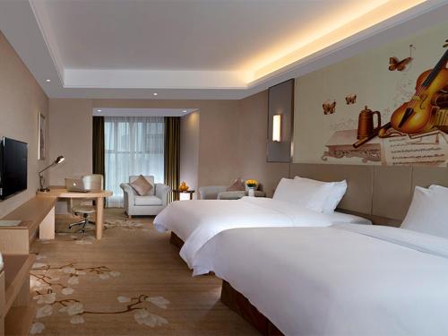 龍崗的住宿－維也納國際店深圳華南城店，酒店客房设有两张床和电视。
