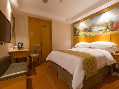 Een bed of bedden in een kamer bij Vienna Hotel Yulin Jincheng Zhenlin