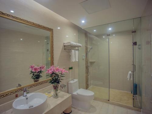 Vienna Hotel Tongcheng Tongkang Road في Tongcheng: حمام مع مرحاض ومغسلة ودش