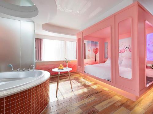 a large pink room with a bed and a tub at Vienna Hotel Shenzhen Exibition Center in Shenzhen