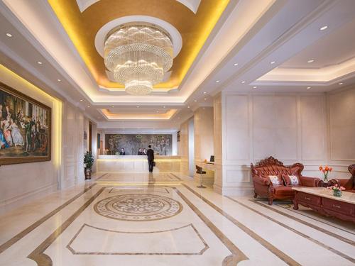 un gran vestíbulo con sofá y lámpara de araña en Vienna Hotel Shenzhen Fuyong Subway Station, en Bao'an