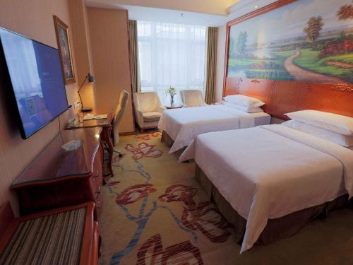 a hotel room with two beds and a flat screen tv at Vienna International Hotel Xi'an Hancheng Lake in Xi'an