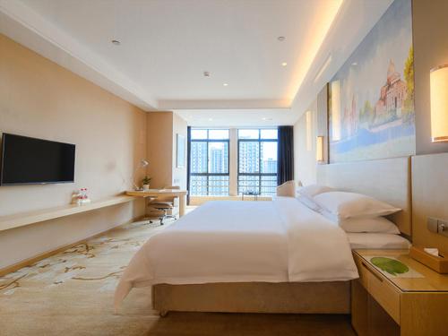 Pokój hotelowy z dużym łóżkiem i telewizorem w obiekcie Vienna International Hotel Hengyang Chuanshan Road Branch w Hengyang