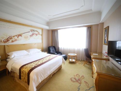 Habitación de hotel con cama y TV de pantalla plana. en Vienna International Hotel Shanghai Pujiang Town en Shanghái