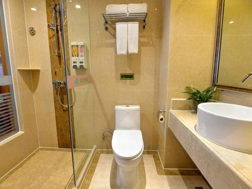 a bathroom with a toilet and a sink and a shower at Vienna Hotel Qinzhou North Area Plaza in Qinzhou