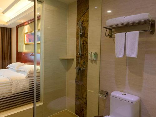 Vienna Hotel Foshan Jihua Road في فوشان: حمام مع دش ومرحاض وسرير