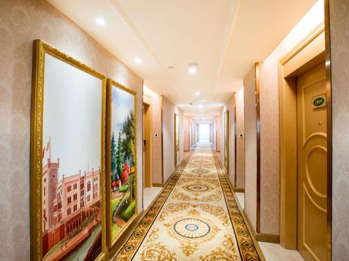 a hallway of a building with paintings on the walls at Vienna Hotel Huizhou Dahuxi in Huizhou
