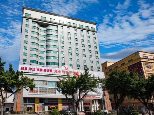 a large white building with a sign on it at Vienna Hotel Huizhou Dahuxi in Huizhou