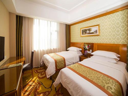Кровать или кровати в номере Vienna Hotel Shandong Yantao Golden Beach Taishan Road