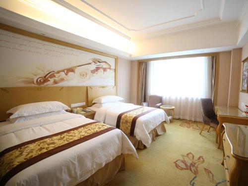 Giường trong phòng chung tại Vienna International Hotel Shanghai Pujiang Town