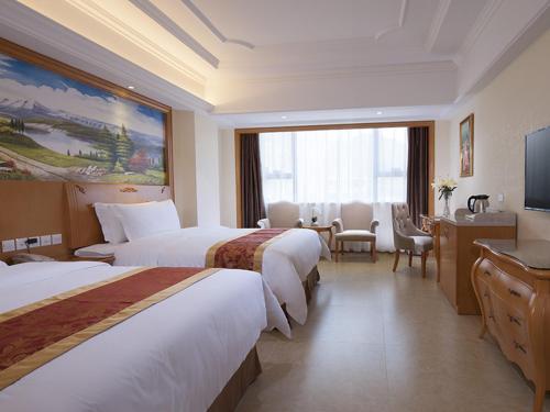 pokój hotelowy z 2 łóżkami i telewizorem w obiekcie Vienna International Hotel Guangdong Yangjiang Zapo Travel Avenue w mieście Lizao