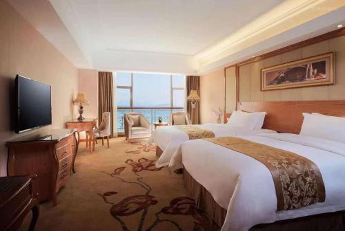 ShanweiにあるVienna Hotel Shanwei Chengqu Xingye Roadのベッド2台、薄型テレビが備わるホテルルームです。