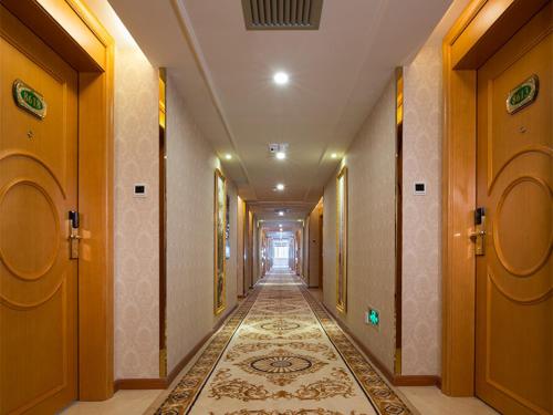 a hallway with a tile floor in a building at Vienna Hotel Foshan Lingnan Pearl Gymnasium Branch in Foshan