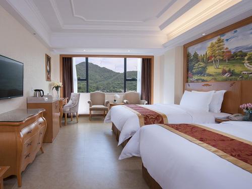 a hotel room with two beds and a large window at Vienna International Hotel Guangdong Yangjiang Zapo Travel Avenue in Lizao