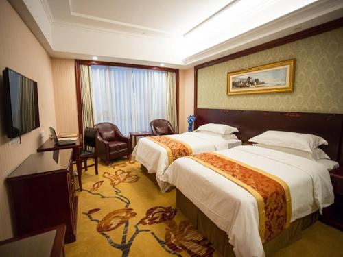 a hotel room with two beds and a television at Vienna Hotel Shanghai Wild Animal Park in Nanhui